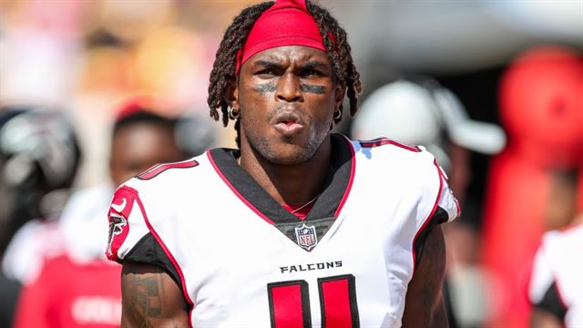 Atlanta Falcons wide receiver Julio Jones autographs a football